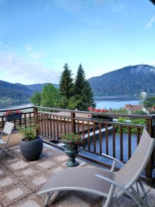 a balcony with chairs and a view of a lake at Le Manoir Au Lac in Gérardmer