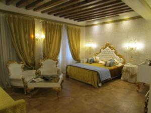 a bedroom with a bed and two chairs and a window at Savoia & Jolanda in Venice