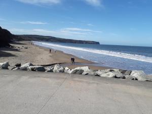 a group of people walking on the beach at Bramblewick in Whitby