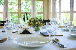 a table with wine glasses and a vase of flowers at Pension Passion in Târgu-Mureş