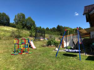 un patio con 2 equipos de juegos en el césped en Gästehaus Lara, en Wimbach