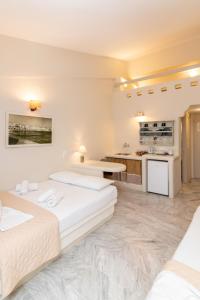 a hotel room with two beds and a kitchen at Fratelli Rooms in Tinos