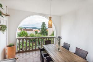 a dining room with a table and a balcony at Apartments Makii in Biograd na Moru