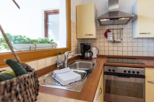a kitchen with a sink and a stove and a window at Apartments Makii in Biograd na Moru