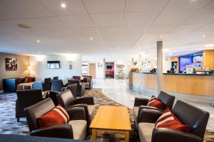 a waiting room with chairs and a bar at Holiday Inn Express Stafford, an IHG Hotel in Stafford