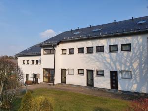 a large white building with a yard at Ferienapartment Resi in Willingen
