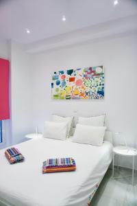1 dormitorio con 1 cama blanca y una pintura en la pared en Amazing Modern Central Apt in Athens en Athens