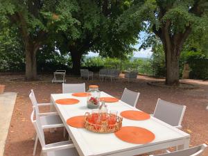 uma mesa branca com placas de laranja em La Souveraine em Saint-Genis-Laval