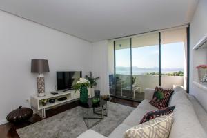 a living room with a couch and a tv at LovelyStay - Luxury 2BR Duplex Apartment in Foz Porto in Porto