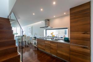 a kitchen with wooden cabinets and a dining room at LovelyStay - Luxury 2BR Duplex Apartment in Foz Porto in Porto