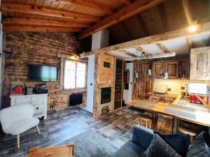 a living room with wooden walls and a table and chairs at Chalet Le Marmouzet in Les Houches +19 photos