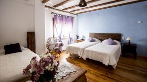 a bedroom with two beds and a chair and a window at La Casa de la Estación in Sarrión