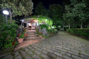 a brick walkway with a gazebo at night at Villa Il Castagno dell'Etna in Maletto