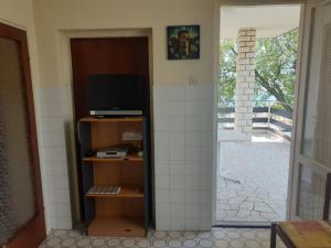 Zimmer mit einem TV und einer Tür zu einer Terrasse in der Unterkunft Apartman Marija in Jadranovo