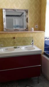 ein Bad mit einem Waschbecken und einem Spiegel in der Unterkunft Ferienwohnung Schloß am Schloßberg in Bad Berka