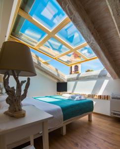 a bedroom with a bed and a large window at Sky Loft Corfu Old Town Apartments in Corfu Town