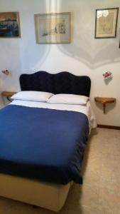 een slaapkamer met een groot bed en een blauwe deken bij Alloggi alla Scala del Bovolo in Venetië