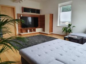 a living room with a couch and a flat screen tv at Dachgeschoss-Apartment in Landeck - 140m² in Landeck