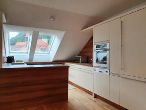 cocina con armarios blancos y ventana grande en Dachgeschoss-Apartment in Landeck - 140m², en Landeck