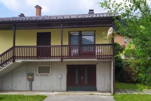 a yellow house with a balcony on top of it at Hiša Belin in Podbela