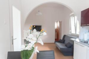 - un vase avec des fleurs blanches dans le salon dans l'établissement Studio ENIG, à Izola