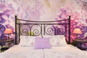 a bedroom with a bed with purple flowers on the wall at Apartments & Rooms Darrer in Poreč