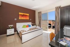 Mariblu Hotel في Xewkija: غرفة نوم بسرير وشرفة