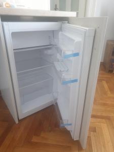 een lege koelkast met de deur open met twee blauwe pijlen bij Studio Yellow - Piata Victoriei in Boekarest