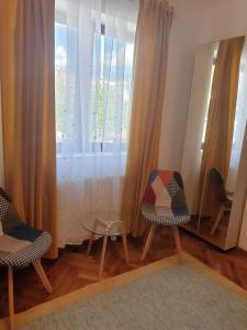 Pokój z 2 krzesłami, lustrem i oknem w obiekcie Studio Yellow - Piata Victoriei w Bukareszcie