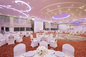 a banquet hall with white tables and white chairs at Ramada by Wyndham Nigde in Nigde