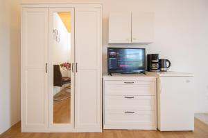 a white cabinet with a television on top of it at Apartments & Rooms Darrer in Poreč