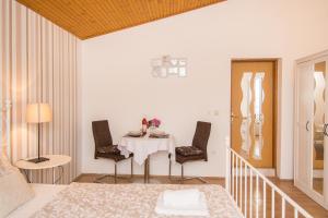 a dining room with a table and two chairs at Apartments & Rooms Darrer in Poreč