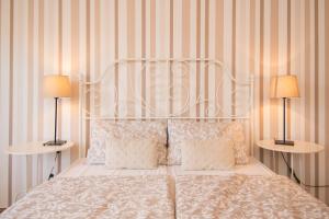 a bedroom with a white bed with two lamps at Apartments & Rooms Darrer in Poreč