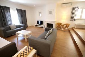een woonkamer met een bank en een open haard bij Villa Rosa A by amcf in Portimão