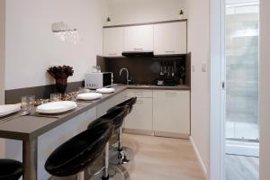 eine Küche mit einem Tisch und zwei schwarzen Stühlen in der Unterkunft Apartments Zara in Rijeka