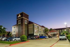 un hotel con coches estacionados en un estacionamiento en La Quinta by Wyndham Houston/Clear Lake-NASA, en Webster