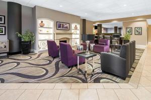 a waiting room with purple chairs and a fireplace at La Quinta by Wyndham Buena Park in La Palma