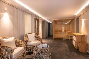 um quarto com cadeiras, uma mesa e uma banheira em The Originals Boutique La Villa Ouest & Spa em Saint-Palais-sur-Mer