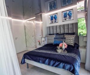 1 dormitorio con 1 cama con edredón azul en ORKAN rooms&restaurant, en Mielno