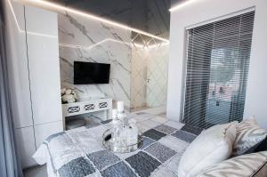 a living room with a table and a tv in it at ORKAN rooms&restaurant in Mielno