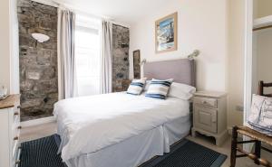a bedroom with a large white bed and a window at The Queens St Ives in St Ives
