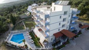 an aerial view of a large white building with a swimming pool at Perivolos Apartments in Dhërmi
