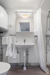 a white bathroom with a sink and a mirror at First Camp Frösön-Östersund in Frösö