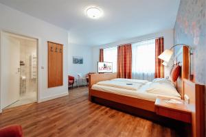 a bedroom with a bed and a desk and a window at Löwen Hotel & Restaurant in Marktbreit