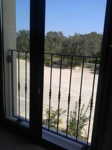 オートラントにあるMasseria Montevergineのバルコニーからビーチの景色を望む窓