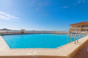 ein großer blauer Swimmingpool vor einem Haus in der Unterkunft Torre Riviera in La Manga del Mar Menor