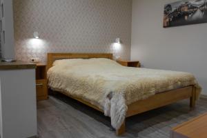 - une chambre avec un lit et 2 tables de chevet dans l'établissement Уютная VIP-студия в центре., à Vinnytsia