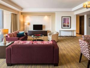 a living room with a couch and a tv at Swissôtel Living Al Ghurair in Dubai
