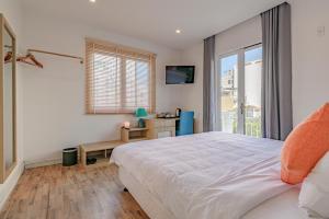 a bedroom with a large white bed and a window at Cocochine Da Nang in Danang