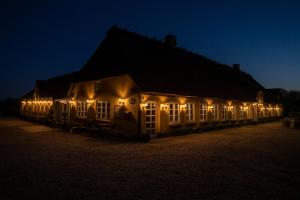 un edificio iluminado por la noche con luces encendidas en Hodde Kro, en Tistrup